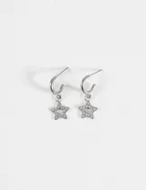 Aros tipo argolla pequeña de acero quirúrgico con dije colgante en forma de estrella decorado con strass.