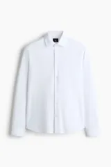 Camisa H&M de corte slim fit, color blanco, confeccionada en tejido elástico con cuello italiano y cierre frontal de botones.