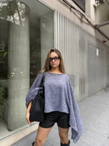 Poncho de hilo liviano en color azul jaspeado, con diseño sin cuello y caída fluida asimétrica.