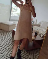 Vestido corto color beige, de corte recto, con tirantes anchos color amarillo y ruedo irregular.