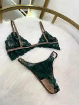 Conjunto de lencería compuesto por un bralette de encaje verde esmeralda con cierre frontal y una tanga a juego con tiras regulables, ambos con detalles de ribetes en color marrón.