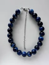 Collar corto compuesto por cuentas esféricas grandes con efecto marmolado en tonos marrones y dorados, con cadena de extensión plateada y cierre de mosquetón.