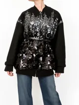 Chaqueta bomber negra con lentejuelas plateadas y mangas largas de punto.
