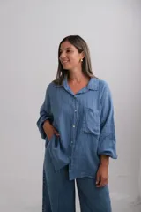 Camisa de lino italiano color azul, con corte holgado, mangas largas con puños elásticos, cuello camisero y bolsillo frontal.