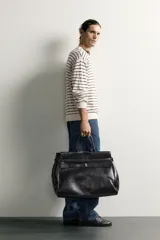 Jersey de punto regular fit, color blanco con rayas horizontales negras, de cuello redondo y manga larga con terminaciones en rib.