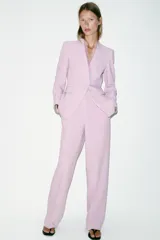 Pantalón de tiro alto color rosado, con pernera recta, bolsillos delanteros y cierre frontal con cremallera, botón interior y gancho.