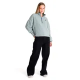 Buzo polar celeste de corte holgado, con cuello alto con cierre de media cremallera azul y logo de la marca bordado en el pecho.