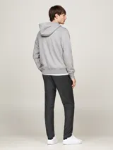 Buzo gris con capucha Tommy Hilfiger, con cierre de cremallera, bolsillos tipo canguro, forro de piel sintética y logo bordado en el pecho.