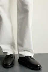 Zapato de vestir tipo derby, color marrón oscuro, con parte superior lisa, horma redonda, cordones y suela con ligero tacón.