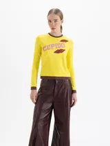 Remera de algodón pima con elastano, color amarillo con detalles en marrón en cuello y puños. Presenta estampa frontal con la palabra 'CUPIDO' en rosa y dibujos de labios rojos.