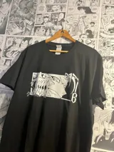Remera negra de algodón con estampado de personaje de anime en blanco.
