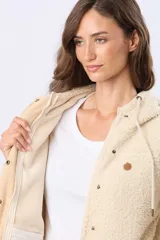 Campera beige con capucha y cordones ajustables, combinada en su parte superior con tejido de corderito y en su parte inferior con diseño capitoné. Cuenta con cierre frontal y broches a presión, además de bolsillos laterales.