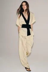 Pantalón de tiro medio Zara Woman Collection, con fajín negro a contraste, pliegues delanteros, pernera ancha, bolsillos laterales ocultos y cierre lateral con cremallera.