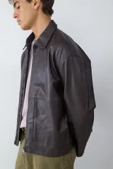 Campera de efecto cuero en color marrón oscuro, con cuello camisero, cierre frontal con cremallera y bolsillos frontales tipo parche.