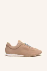 Zapatillas de gamuza color tostado, con cordones celestes, suela de caucho blanca y diseño de inspiración retro.