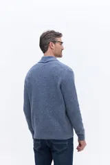 Cárdigan de tejido de punto color azul, con cuello tipo shawl y cierre frontal de botones. Presenta un diseño de textura acanalada y calce regular.