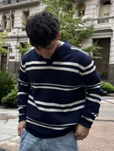 Buzo tejido de punto con diseño de rayas horizontales en azul marino y blanco, cuello polo y mangas largas.