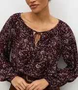 Blusa de viscosa con estampado de follaje, escote canoa con lazo delantero y mangas largas abullonadas.