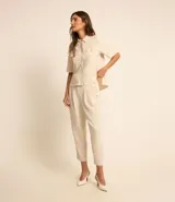 Camisa color fucsia de tejido airflow, con cuello camisero, mangas cortas con pliegues, cierre frontal con botones metalizados y bolsillos con solapa en el pecho.