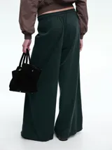 Pantalón de corte holgado y pierna ancha, confeccionado en pana color marrón. Presenta cintura elástica con cordón ajustable y diseño de tiro medio.