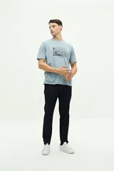 Remera de manga corta color beige con estampado fotográfico en el pecho. Presenta un corte regular y cuello redondo.