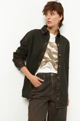 Camisa de jean celeste de manga larga con botones marrones.