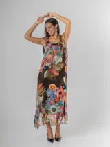Vestido largo tipo musculosa confeccionado en seda italiana, con diseño de flores abstractas en tonos saturados y nudo regulable en el hombro.