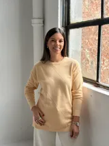 Sweater de punto color manteca con diseño de rombos en relieve, cuello redondo y mangas largas con puños ajustados.