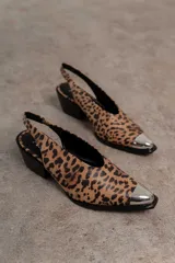 Zapato tipo slingback color crema con punta afilada y detalle metálico plateado. Tacón bloque color negro.