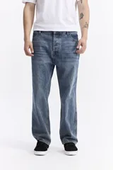 Jean baggy de hombre, color azul claro, con tiro medio, corte amplio en piernas y cadera, y pasacinto.