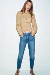 Jeans de tiro alto con corte mom fit, diseño de cinco bolsillos y raya planchada frontal. Presenta cierre frontal con cremallera y botón.