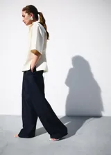 Pantalón de traje tiro medio, corte recto y largo, con diseño de raya diplomática, pinzas y bolsillos laterales.