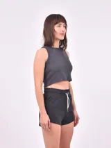 Musculosa corta negra de tejido de punto acanalado, con cuello redondo y sisas amplias.