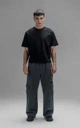 Pantalón tipo jogger gris melange de corte baggy y silueta amplia, confeccionado en frisa de algodón. Presenta cintura elástica, bolsillos laterales de mano y bolsillos estilo cargo con solapa y cierre en los laterales.