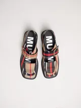 Zapatos tipo guillermina con punta cuadrada, confeccionados en lona resistente con estampado de cuadros escoceses en tonos beige, rojo y negro. Presentan una correa ajustable con hebilla metálica color bronce y una suela con taco de 4 cm.