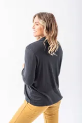 Saco negro de lanilla con corte entallado, terminaciones finas, bolsillos funcionales y composición de 40% viscosa, 38% poliéster, 10% poliamida y 12% lana.