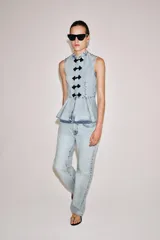 Pantalón de jean de tiro bajo y corte recto, con diseño de cinco bolsillos y cierre frontal con cremallera y botón metálico. Presenta un lavado claro.