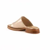 Zueco artesanal de cuero color dorado, con suela plana y taco bajo de madera con plataforma.