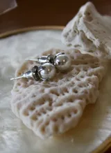 Aros pequeños con perlas blancas y engarce de acero quirúrgico.