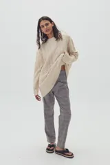 Sweater beige de lana y alpaca con diseño de ochos, cuello redondo y corte oversized.