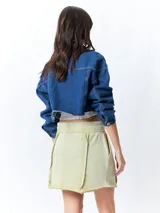 Minifalda color beige con elástico en la cintura, cordones ajustables y costuras marcadas en los laterales.