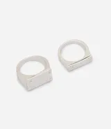Kit de dos anillos de metal color plateado, con diseño geométrico y detalles decorativos inspirados en tornillos en los extremos.