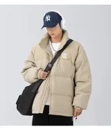 Campera puffer color nude (beige claro) con diseño acolchado. La parte superior de los hombros y el cuello son de pana acanalada. Presenta un bordado en la espalda con la palabra "Chingona" en tipografía gótica blanca. Posee tiras regulables en la cintura.