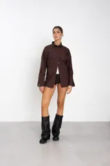 Botas de caña alta confeccionadas en ecocuero negro, con diseño holgado y suela plana con plataforma baja.