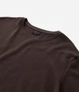 Remera de manga corta con cuello redondo, confeccionada en tejido tipo waffle con textura nido de abeja. Presenta un diseño liso y estructurado, ideal para un look casual y versátil.