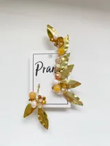 Aros trepadores dorados con hojas y piedras de color naranja, blanco y marrón.