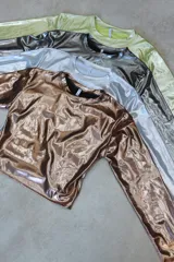 Top plateado brillante de mangas largas con espalda descubierta y lazos.