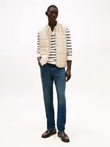 Chaleco acolchado color beige con diseño geométrico de cuadros, cuello estilo béisbol, cierre de cremallera y logo de Tommy Hilfiger bordado en el pecho.