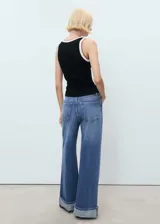 Top de punto fino sin mangas, con cuello redondo y tirantes anchos. Presenta un diseño entallado con detalles de ribetes en contraste en el cuello y las sisas.