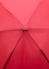 Paraguas mini plegable de color rojo, con tira de sujeción para la muñeca y detalle de placa metálica grabada con el logo de la marca.